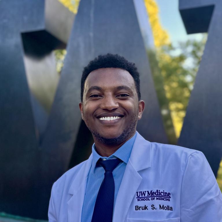 Bruk smiling at the camera in a white coat