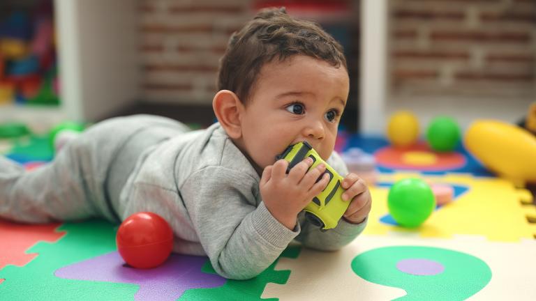 Toddler with toy in mouth