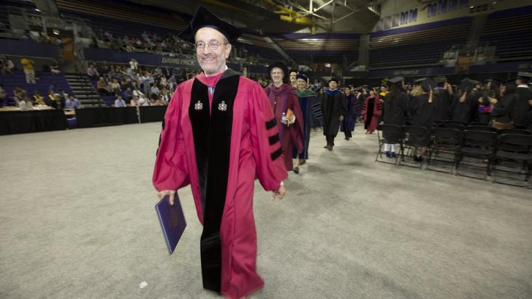 Howard Frumkin walks in graduation regalia