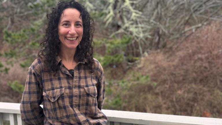 Jamie Donatuto smiles standing outside with trees in the background.