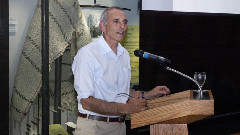 Man standing at lectern speaking to an audience.
