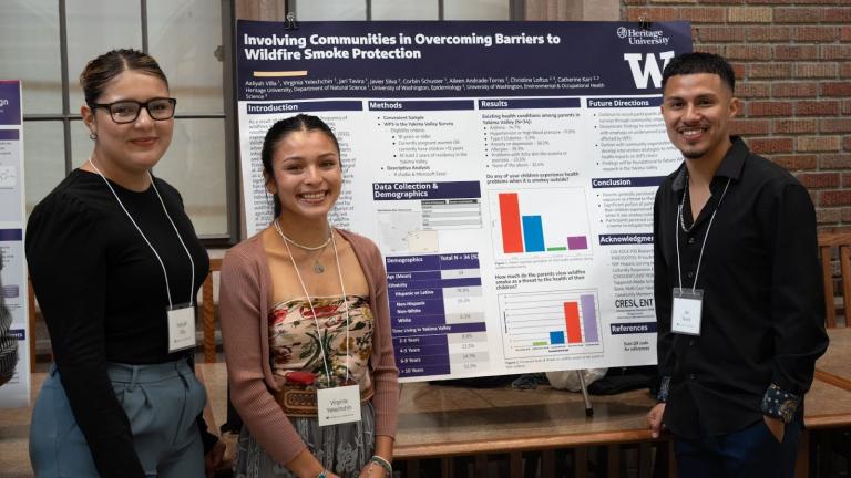 Three people stand around a research poster smiling. The poster title is, "Involving Communities in Overcoming Barriers to Wildfire Smoke Protection"