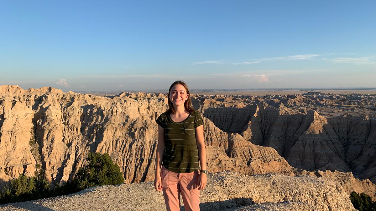 UW senior Natalie Peterson standing in front of a canyon in the Badlands.