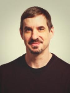 Dr Leader, a young white man with short brown hair and a beard