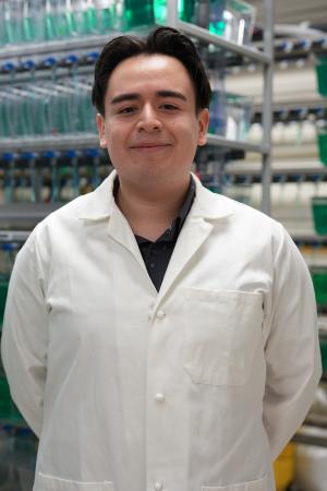Leo Diaz stands in front of fish tanks in a lab.