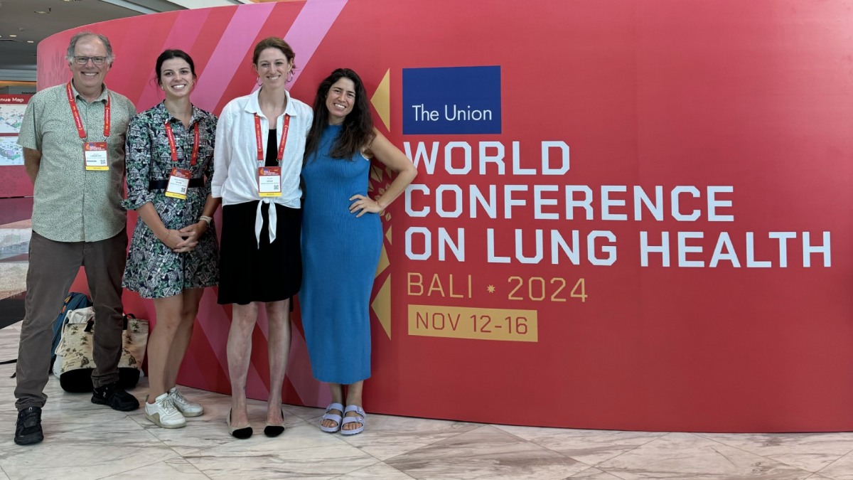 Cangelosi, Olson, Wood and Codsi stand together smiling in front of a sign reading "The Union World Conference on Lung Health, Bali 2024, Nov 12-16"