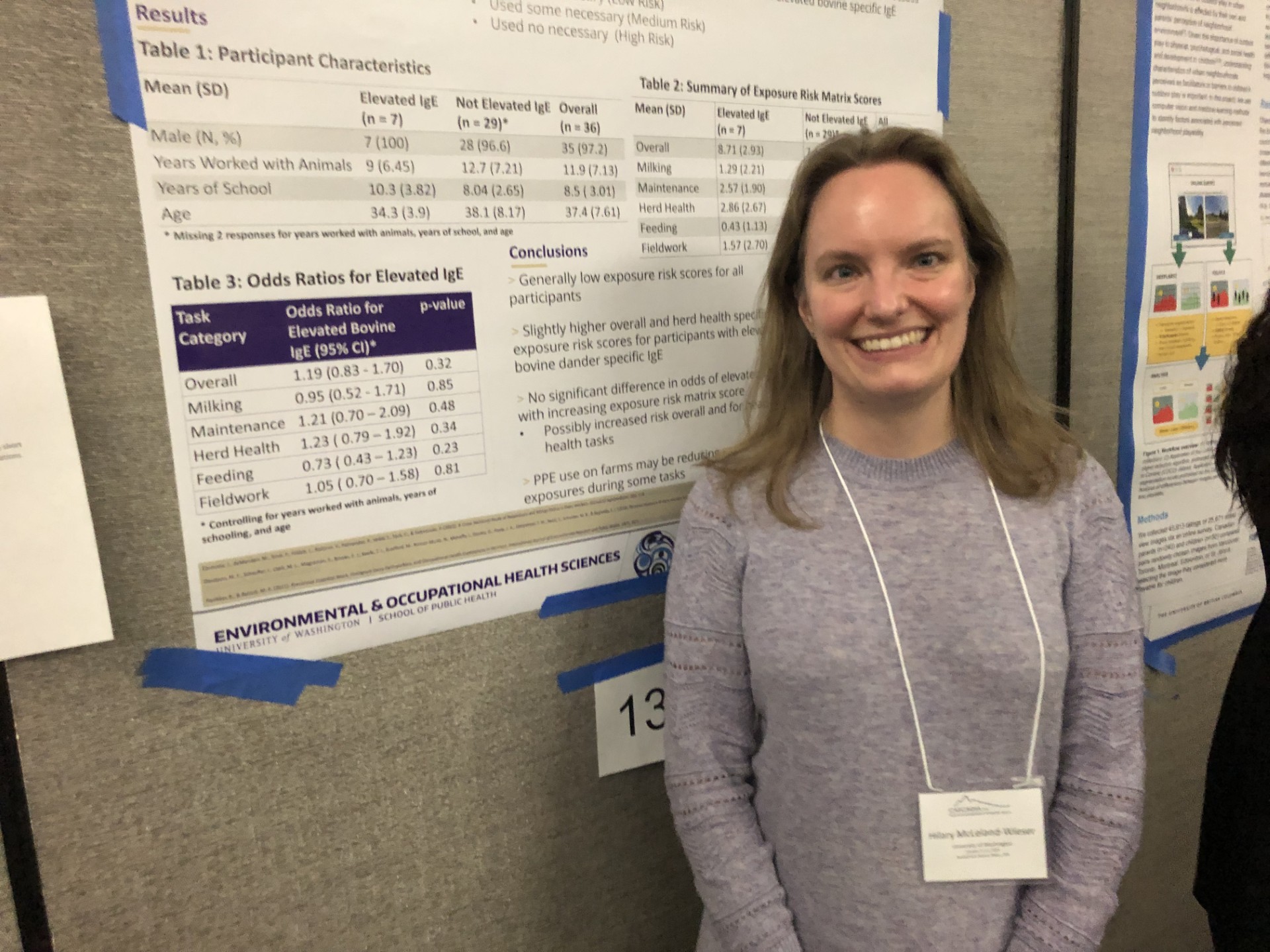 Hilary McLeland-Wieser smiles standing in front of a research poster.